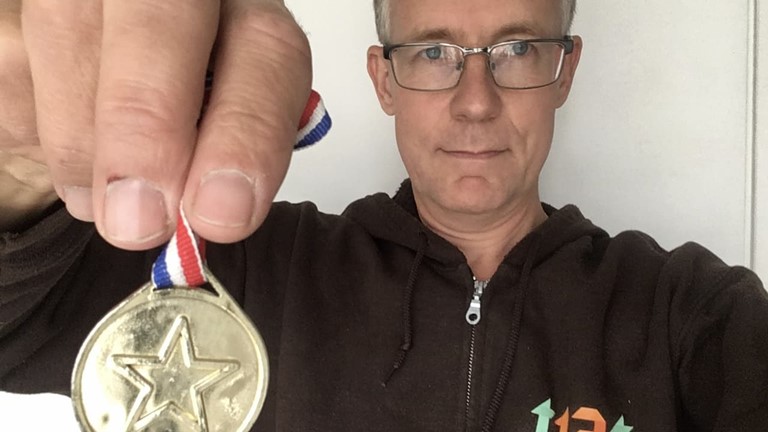 Bild föreställandes en person som håller en medalj. Bild till webbinariet Alla vinner på digital tillgänglighet.