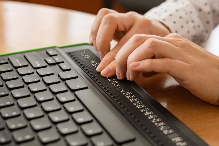 Händer som använder ett tangentbord med blindskrift