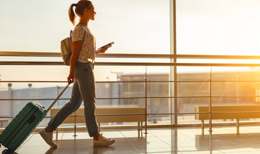 Kvinna går med rullväska